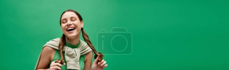 Téléchargez les photos : Une jeune femme dans la vingtaine riant joyeusement dans un cadre de studio dynamique. - en image libre de droit