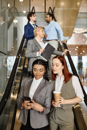 An interracial group of business people stands on an escalator.