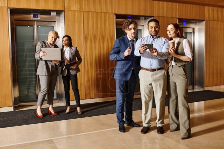 Téléchargez les photos : Groupe multiculturel de gens d'affaires debout ensemble dans l'ascenseur. - en image libre de droit