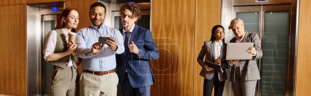 Photo for A diverse group of business professionals gathers in front of an elevator. - Royalty Free Image