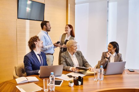 Photo for Diverse group of people discussing in a professional meeting around a conference table. - Royalty Free Image
