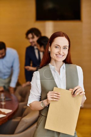 A woman confidently holds a paper in front of a diverse group of business people.