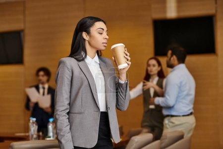 Foto de Una mujer en traje disfruta de una taza de café. - Imagen libre de derechos