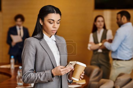 Intercultural businesswoman in suit savoring a coffee break.