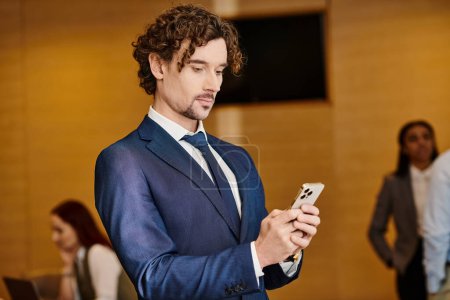 Téléchargez les photos : A stylish man in a suit engrossed in his cell phone. - en image libre de droit