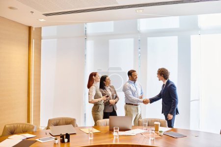 Diverse business professionals engaging in a handshake gesture inside a conference room.