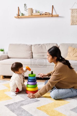 Una joven madre asiática juega felizmente con su pequeño hijo en el suelo en su acogedora sala de estar.