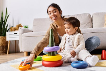 Une jeune mère asiatique interagit joyeusement avec son petit fils, jouant et collant sur le sol confortable du salon.