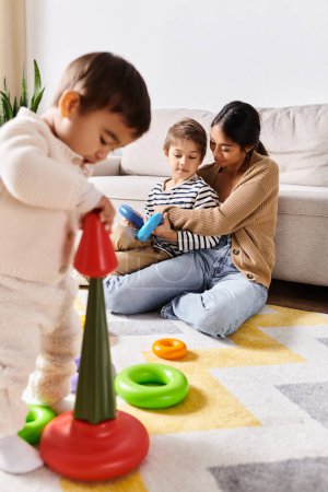 Young Asian mother joyfully engages with her two little sons in playing and exploring with toys in the cozy living room.