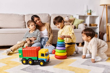 Foto de Una joven madre asiática y sus hijos pequeños participan en el juego, riendo y explorando juguetes en su acogedora sala de estar. - Imagen libre de derechos