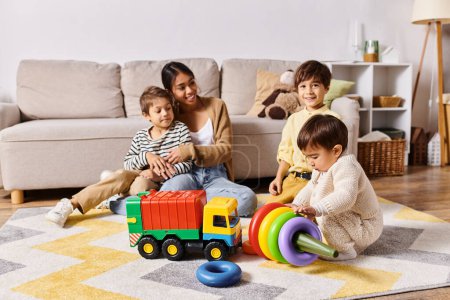 Une jeune mère asiatique et ses petits fils jouent joyeusement avec des jouets dans leur salon.