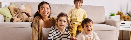Una joven madre asiática y sus hijos pequeños están cómodamente sentados juntos en un sofá en su casa sala de estar.
