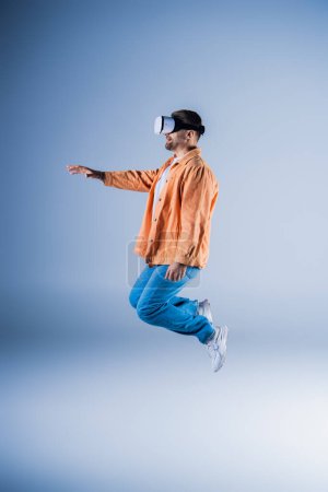 A man in an orange jacket and blue pants is soaring through the air.