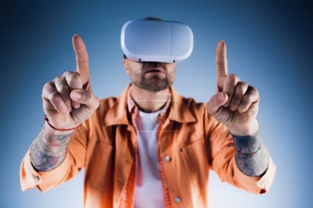 Un hombre con una camisa naranja explora el mundo digital con un auricular de realidad virtual en un entorno de estudio.