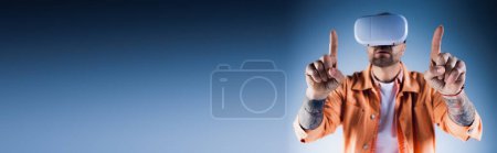 Photo for A man in an orange jacket stands in a studio, holding up two fingers in a gesture of peace and unity. - Royalty Free Image