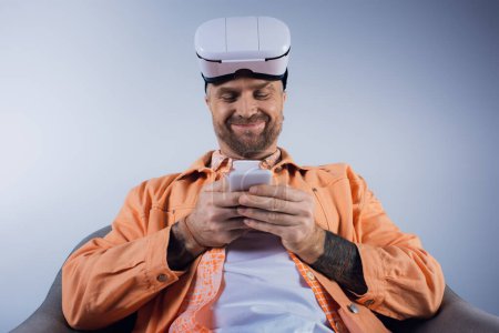 Ein Mann in orangefarbenem Hemd konzentriert sich auf sein Handy und interagiert mit dem Gerät.