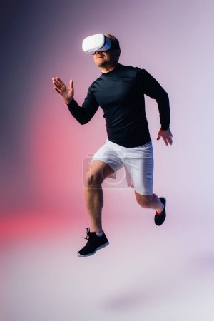 Un homme en chemise noire et short blanc saute joyeusement dans les airs, créant des ombres dramatiques dans un décor de studio.