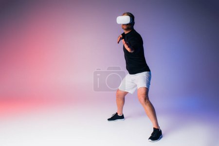 Photo for A man in a black shirt and white shorts gracefully moves in a studio setting. - Royalty Free Image