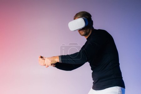 A man wearing a virtual reality headset in a studio setting, fully engrossed in the digital world.