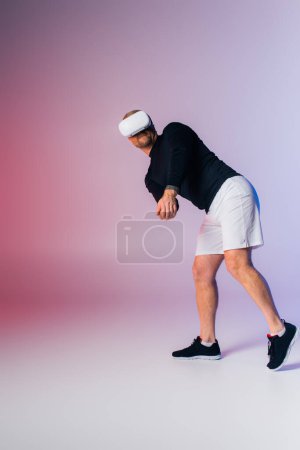 Foto de Un hombre con una camisa negra y pantalones cortos blancos está jugando enérgicamente al tenis en una cancha. - Imagen libre de derechos