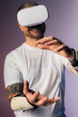 A man in a white t-shirt explores virtual reality in a studio setting wearing a white VR headset.