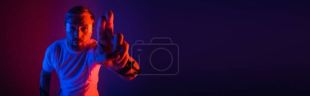 Photo for A man in a white shirt, wearing smart glasses, is making a hand gesture in a virtual reality studio setting. - Royalty Free Image