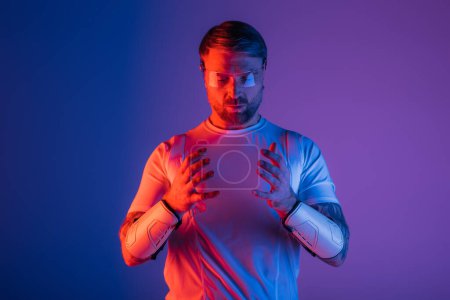 Ein Mann im weißen Hemd, die Hände ineinander verschlungen, strahlt Ruhe und Gelassenheit in einem Studio-Setting mit Virtual-Reality-Elementen aus.