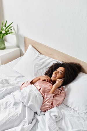 Une poupée repose paisiblement sur un lit soigneusement fait avec des draps blancs, ajoutant une touche de fantaisie au cadre confortable de la chambre.