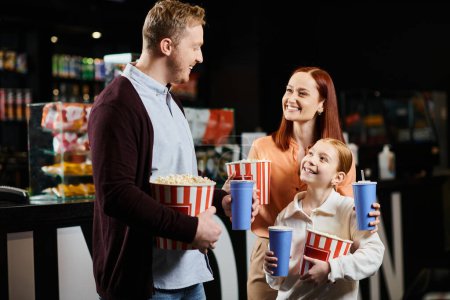 A family joyfully holds popcorn while sharing a moment together.