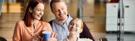 Photo for Family are smiling together in a cinema, displaying a strong bond and happiness. - Royalty Free Image