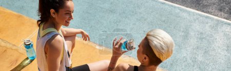 Photo for Two young women, sporty and energized, stand side by side on the basketball court in the warm summer sun. - Royalty Free Image