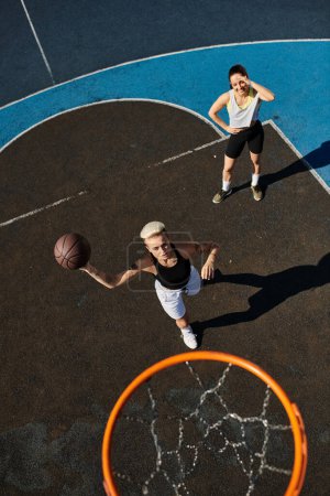 Dos mujeres atléticas en acción en una cancha de baloncesto, driblando, disparando y compitiendo en un emocionante juego bajo el sol brillante.