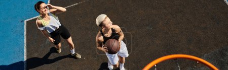 Téléchargez les photos : Les femmes jouent un jeu intense de basket sur un terrain extérieur sur une journée ensoleillée d'été. - en image libre de droit