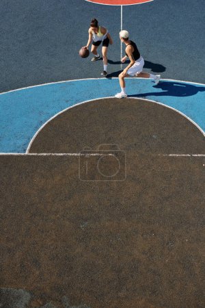 młode kobiety grające w koszykówkę na boisku zewnętrznym, angażujące się w konkurencyjną i energiczną grę.