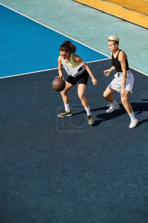 Deux jeunes femmes athlétiques se tiennent triomphalement au sommet d'un terrain de basketball, incarnant force, travail d'équipe et amitié.