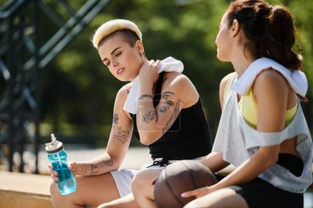 Deux jeunes femmes, athlétiques et pleines d'esprit, profitent d'un jeu de basket-ball en plein air par une journée ensoleillée d'été.