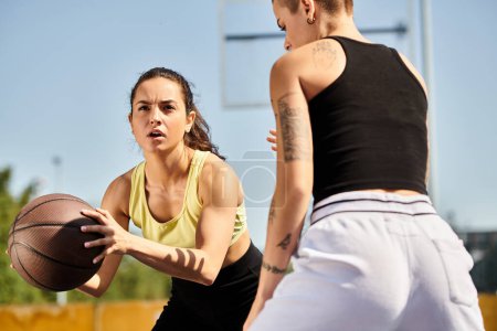 Zwei sportliche junge Frauen stehen draußen, eine hält einen Basketball in der Hand und verkörpert an einem sonnigen Tag Freundschaft und Sportlichkeit.