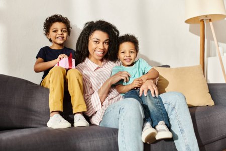 fröhliche afrikanisch-amerikanische Familie von drei fröhlich lächelnd in die Kamera, anwesend in der Hand, Muttertag