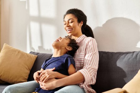 joyeuse mère afro-américaine tenant son petit fils joyeux et souriant heureux, parentalité moderne