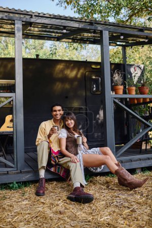 Ein Mann und eine Frau sitzen auf einer Bank vor einem Schuppen und genießen einen romantischen Kurzurlaub in einer ruhigen natürlichen Umgebung.