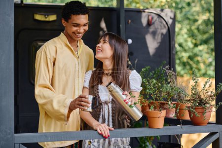 Un homme et une femme profitent d'un moment paisible sur un porche entouré de plantes en pot luxuriantes.