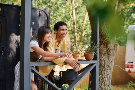 Ein Mann und eine Frau sitzen neben einem Baum auf einer Veranda und genießen die ruhige Natur.