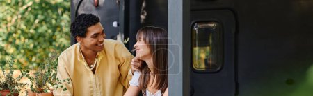Foto de Un hombre y una mujer se paran fuera de un tren, mirándose a los ojos con una mirada de amor y aventura. - Imagen libre de derechos