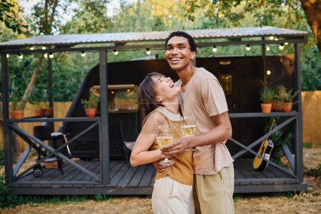 Téléchargez les photos : Un homme et une femme, un couple interracial, se tiennent côte à côte devant un camping-car, prêts pour une escapade romantique. - en image libre de droit