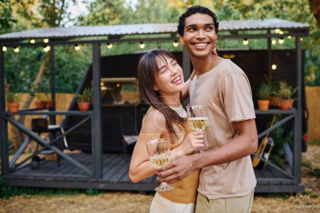 Téléchargez les photos : Un homme et une femme clignent des verres à vin, profitant d'un moment romantique dans un camping-car confortable. - en image libre de droit