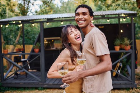 Foto de A man and woman hold glasses of wine, enjoying a romantic moment together. - Imagen libre de derechos