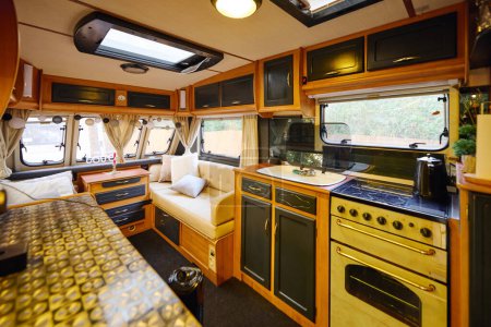 Téléchargez les photos : Cuisine confortable et salon dans un véhicule récréatif pour une escapade romantique. - en image libre de droit