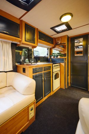 Foto de Caravana con acogedora cocina y sala de estar para una escapada romántica aventura. - Imagen libre de derechos