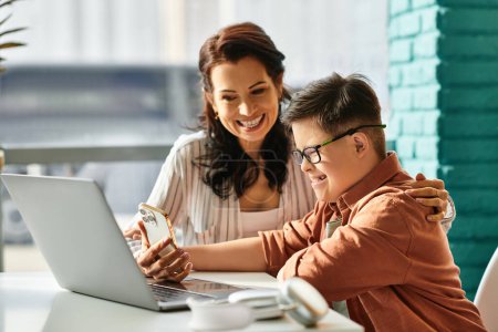entzückender inklusiver Junge mit Down-Syndrom, der Zeit mit seiner fröhlichen Mutter vor dem Laptop verbringt