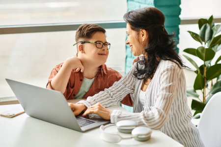 Photo for Cute inclusive boy with Down syndrome spending time with his happy mother in front of laptop - Royalty Free Image